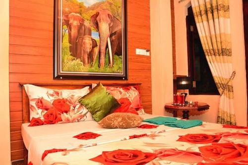 a bedroom with a bed with red roses on it at Linda Cottage in Galle