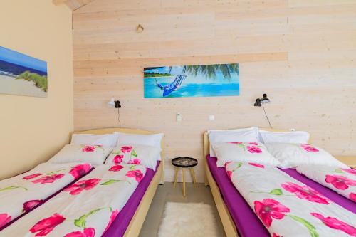 two beds in a room with pink flowers at Holiday Home Matthäus am Corfutrail, Ferienoase im Olivenhain 3 km zum Meer in Giannádes