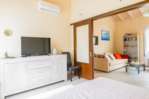 a living room with a television and a couch at Holiday Home Matthäus am Corfutrail, Ferienoase im Olivenhain 3 km zum Meer in Giannádes