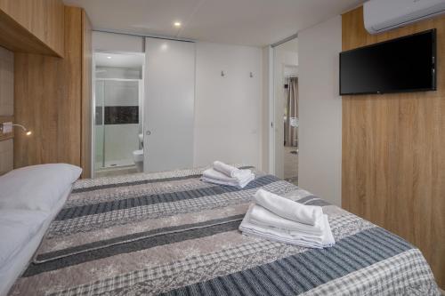 Un dormitorio con dos camas con toallas encima. en Premium Camping Homes Santa Marina, Lanterna, en Poreč