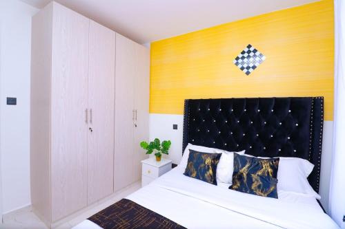 a bedroom with a bed with a black headboard at First class apartments in Kiambu