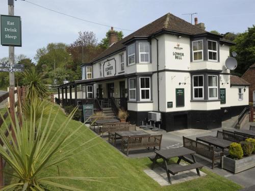 ein Gebäude mit Tischen und Bänken davor in der Unterkunft Lower Bell in Aylesford