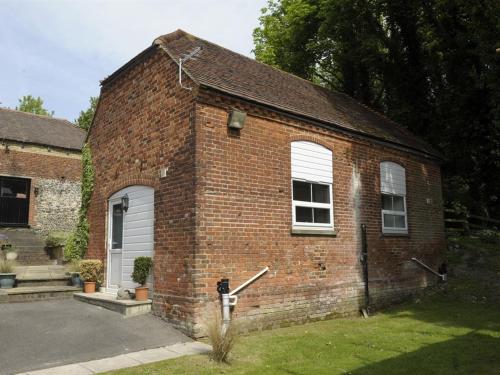 a brick building with a white door and windows at Lower Bell in Aylesford