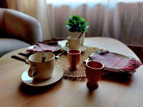 una mesa con tazas de café y servilletas. en MyDeer - Deluxe rooms & shared kitchen en Malmedy