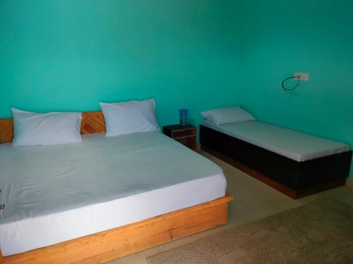 Gupta KāshiにあるShree Neelkanth Resortのベッド2台、ベッド1台、ベンチが備わる客室です。
