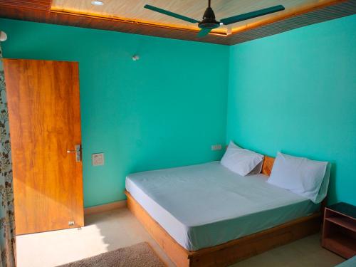 Gupta KāshiにあるShree Neelkanth Resortの青い壁のベッドルーム1室