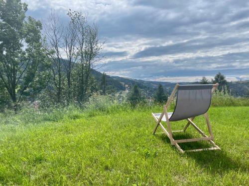 a chair sitting in the grass in a field at Przystanek 470 in Krościenko