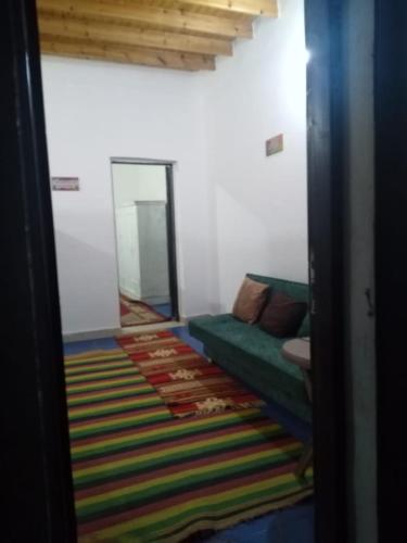 sala de estar con sofá verde y alfombra colorida en بيت ابو سليم, en Dahab