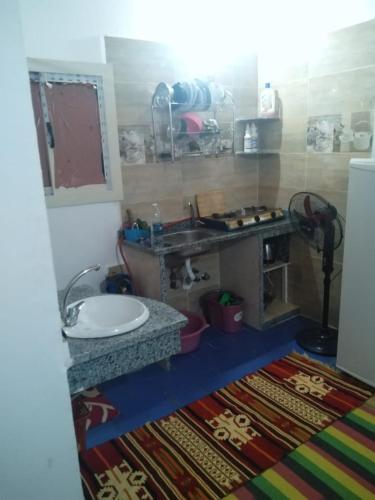 una pequeña cocina con fregadero y encimera en بيت ابو سليم en Dahab