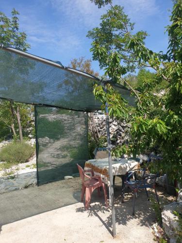 a patio with a table and chairs under a canopy at Robinson Haus PanoramA No Electricity in Zagvozd