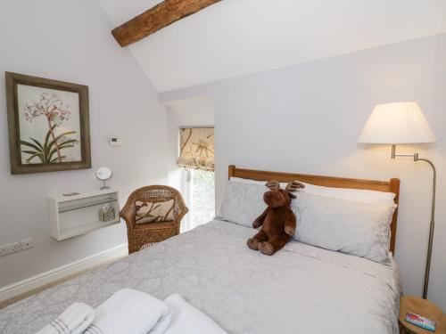 a teddy bear sitting on top of a bed at The Grain Store in Witney