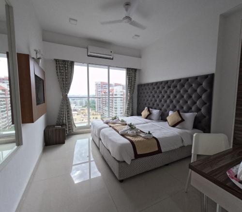 1 dormitorio con cama grande y ventana grande en Maxxvalue Apartment Chandivali, en Bombay