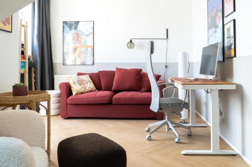 salon z czerwoną kanapą i biurkiem w obiekcie Old Town Gem Designer Apartment - Centre Location - Families - Remote Work w Gdańsku