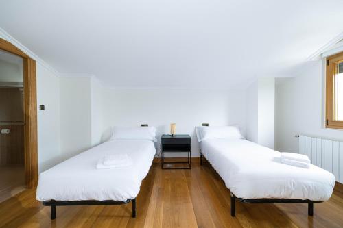 three beds in a row in a room at Tanbolin "with outlet for ELECTRIC vehicle" By Kabia Gestión in Gautegiz Arteaga