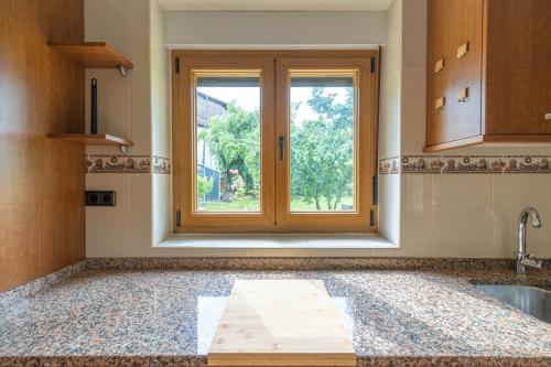 a kitchen with a window and a bath tub at Tanbolin "with outlet for ELECTRIC vehicle" By Kabia Gestión in Gautegiz Arteaga