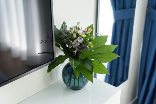a vase of flowers sitting on a table next to a tv at Alma Suites in Naples