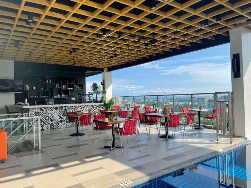 a restaurant with red chairs and tables on a balcony at The Residences at BCCT in Manila