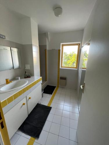 baño blanco con lavabo y ventana en Grand Appartement Hypercentre avec Terrasse et Parking, en Poitiers
