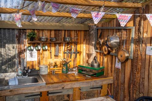 een keuken met een wastafel en een aanrecht met keukengerei bij The Paddock Wildcamp in Perranporth