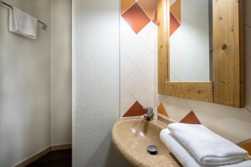 فندق ريزيدنس بيير آند فاكانسيز لا ريفيير في شامونيه مون بلان: حمام مع حوض ومرآة