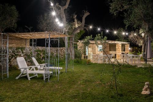 a garden at night with chairs and a gazebo at Tenuta San Lorenzo in Otranto