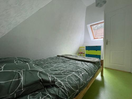 une chambre avec un lit avec une couette verte dans l'établissement Duplex au calme jardinet Spa, à Plescop