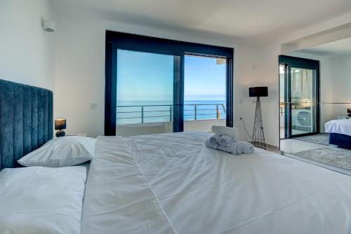 een slaapkamer met een groot wit bed en grote ramen bij Sea Wave Apartment in Kruče