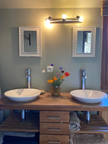 deux lavabos sur un comptoir en bois dans une salle de bain dans l'établissement Le gîte du Quai aux Gîtes de Cormenin, à Saint-Hilaire-sur-Puiseaux