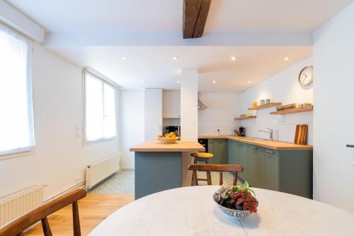 eine Küche mit einem Tisch und einer Obstschale darauf in der Unterkunft Appartement Meuse & Mono, en hyper centre in Charleville-Mézières