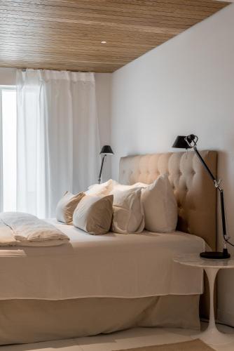 a bedroom with a bed with white pillows and a window at Scandinavian Deluxe House With Private Sauna at Kamppi in Helsinki