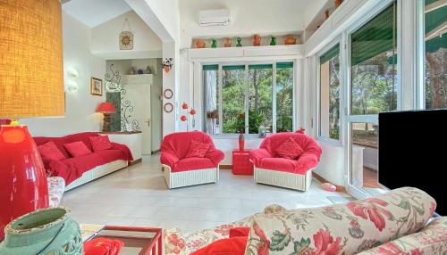 a living room with red chairs and a couch at Villa Susy al mare in La Maddalena