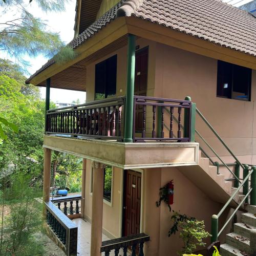 a house with a balcony on the side of it at Oceanview Bungalows by EAT in Karon Beach
