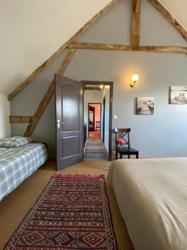 - une chambre avec 2 lits et une porte avec un tapis dans l'établissement Le gîte du Quai aux Gîtes de Cormenin, à Saint-Hilaire-sur-Puiseaux