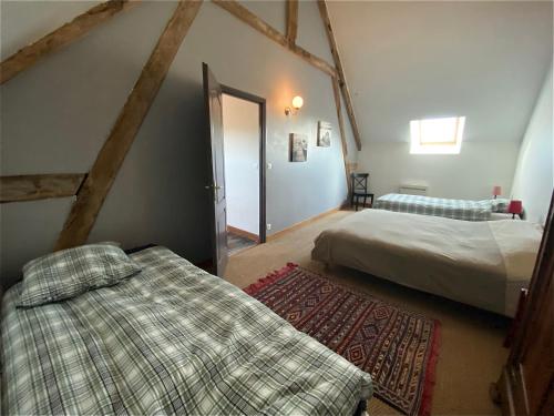 a bedroom with two beds and an attic at Le gîte du Quai aux Gîtes de Cormenin in Saint-Hilaire-sur-Puiseaux