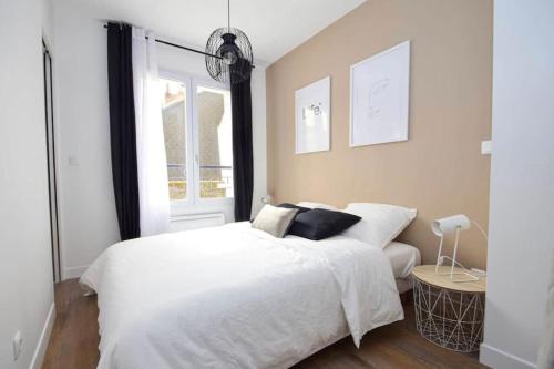 um quarto com uma cama branca e uma janela em Charmant 2P centre ville Orléans em Orléans