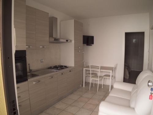 eine Küche mit einem Tisch und Stühlen im Zimmer in der Unterkunft Condominio Belletti in Lignano Sabbiadoro