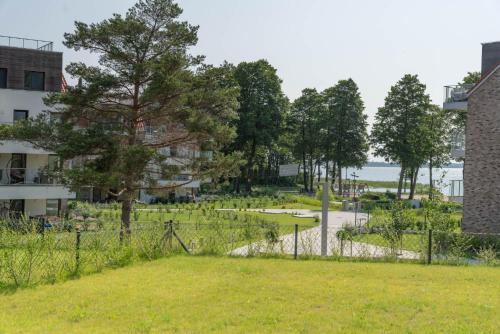 a park with a fence and a tree at Nautica Resort in Giżycko