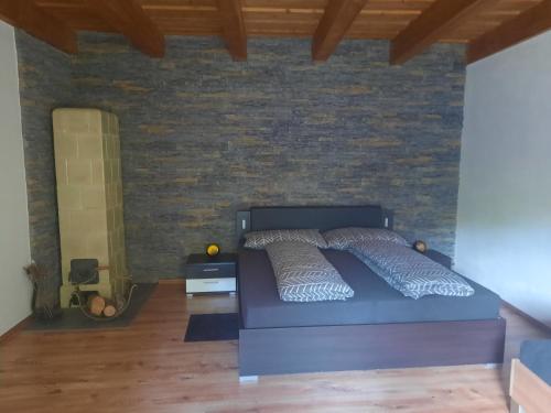 1 dormitorio con cama y pared de ladrillo en Domček pod lesíkom, en Banská Štiavnica