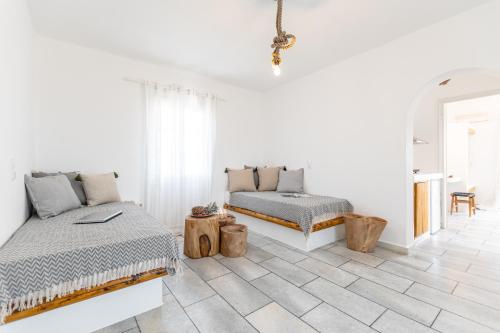 a white room with two beds and a couch at Naxian Serenity Suites in Agia Anna Naxos