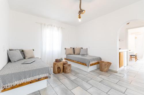 アギアアンナ・ナクソスにあるNaxian Serenity Suitesの白い部屋(ベッド2台、ソファ付)
