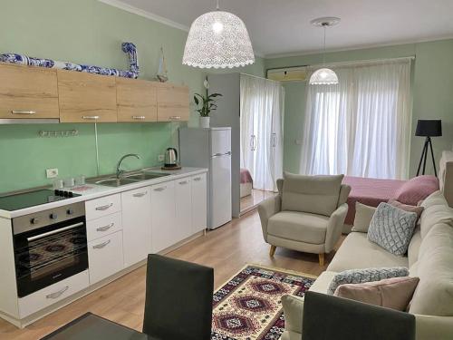 ein Wohnzimmer mit einem Sofa und einer Küche in der Unterkunft The Ionian Comfort Apartment- Beachfront Lungomare Promenade in Vlorë
