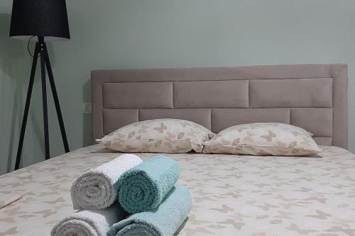 ein Bett mit zwei Kissen und Handtüchern darauf in der Unterkunft The Ionian Comfort Apartment- Beachfront Lungomare Promenade in Vlorë