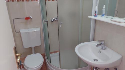 La salle de bains est pourvue d'une douche, d'un lavabo et de toilettes. dans l'établissement PORT, à Makarska