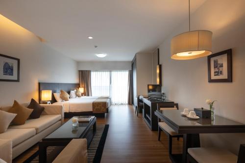 une chambre d'hôtel avec un lit et un salon dans l'établissement Kantary Hotel Kabinburi, à Kabin Buri