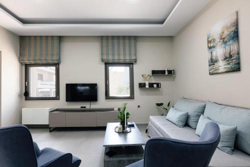a living room with a couch and a tv at Estia Comfort House in Chania