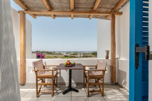 una sala da pranzo con tavolo e sedie sul balcone di Naxian Serenity Suites ad Agia Anna Naxos