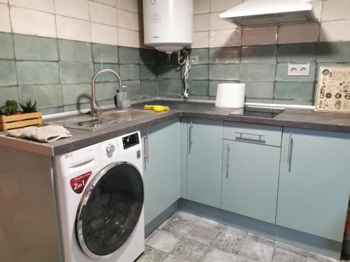 a kitchen with a washing machine and a sink at Apartamento con encanto 2 hab céntrico-ayuntamiento in Santander