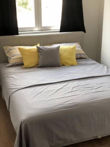 Una cama con almohadas amarillas y blancas. en DreamLux DM With Parking, en Skopje