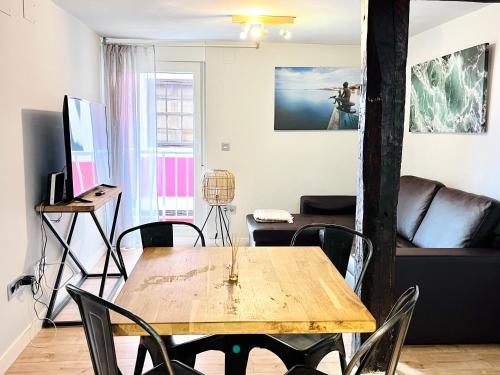a living room with a wooden table and chairs at Apartamento con encanto 2 hab céntrico-ayuntamiento in Santander