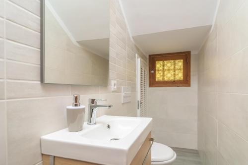 uma casa de banho branca com um lavatório e um WC em Ca'n Torronet em Port d'Alcudia